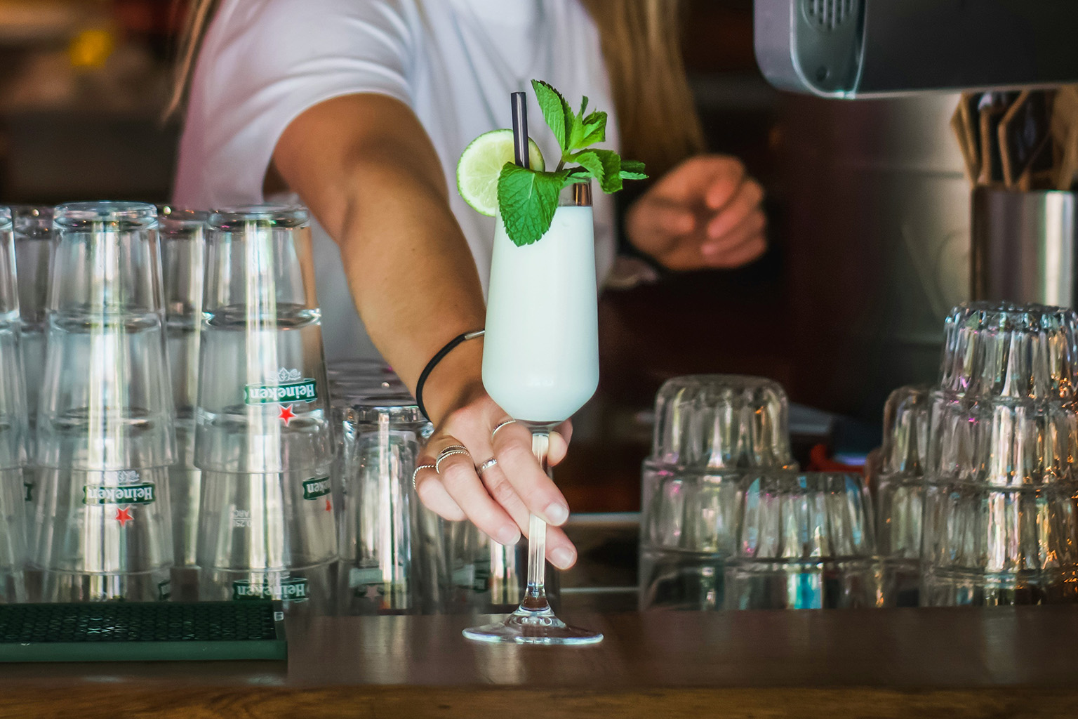 Bartender making colorful tropical drinks at a beach bar in the Caribbean.
