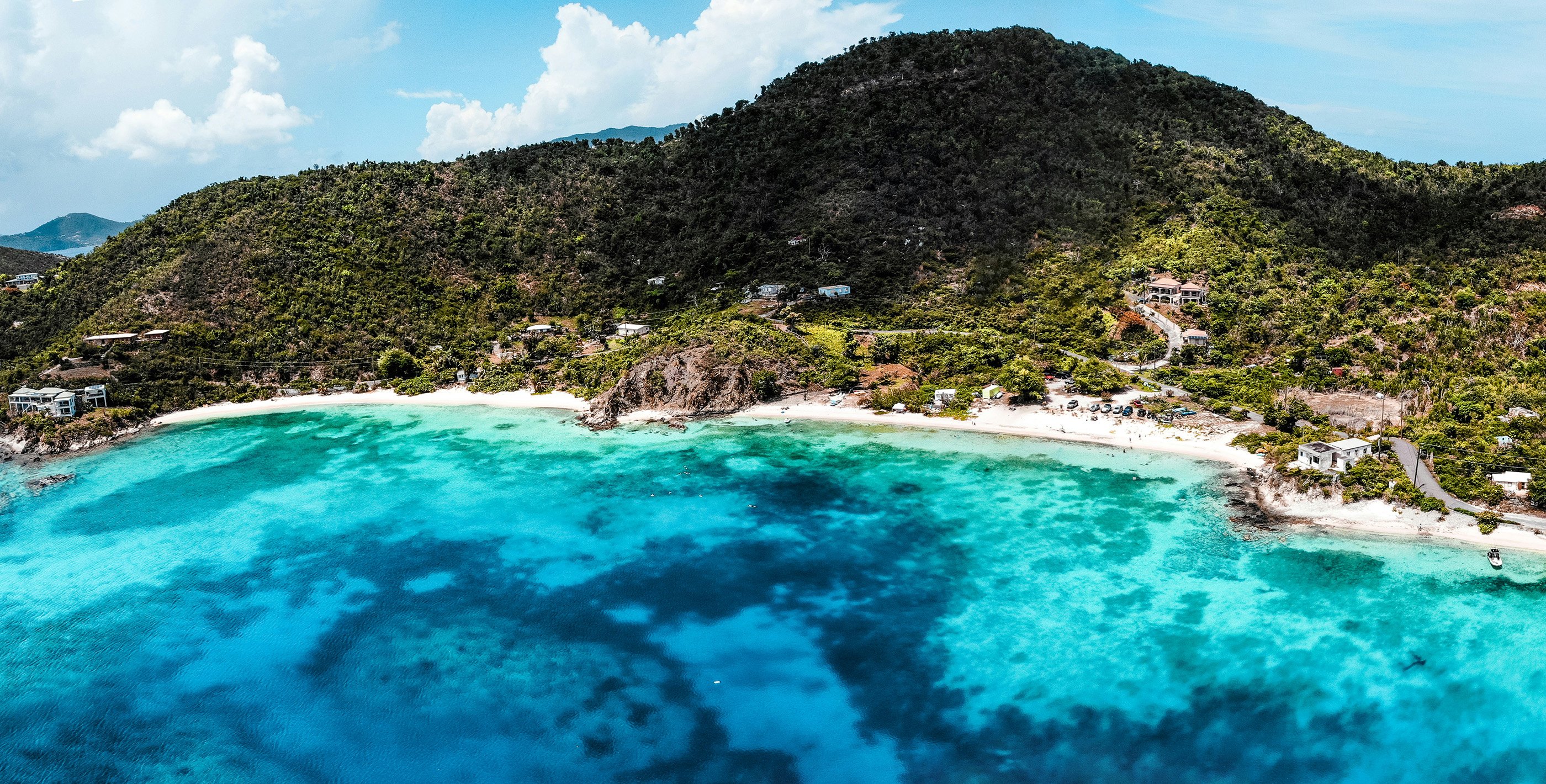 Close-up of a tropical island in the Caribbean with aqua blue water and a pristine beach.