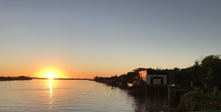 Sunset over the Paraguay River from a bridge, highlighting the beauty of the best places to live in Paraguay.