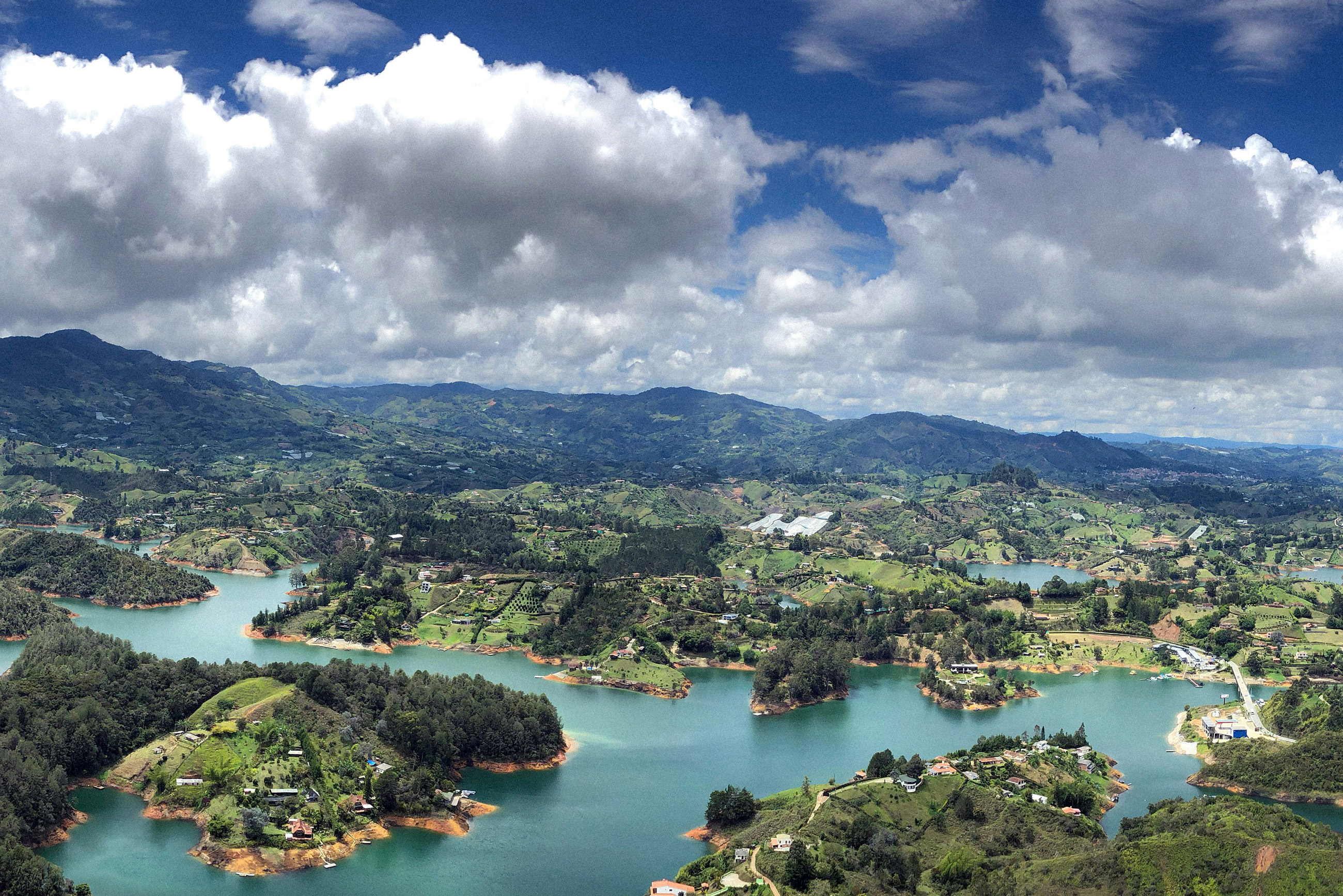 Several islands forming the town of Guatapé, Colombia, set against the expansive Peñol-Guatapé Reservoir, showcasing the serene natural beauty of Colombia compared to Mexico’s coastal landscapes.