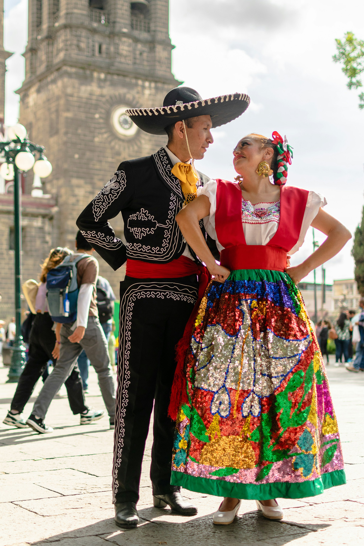 Traditional Mexican dancers in colorful costumes, performing a lively folk dance, representing the cultural vibrancy of Mexico compared to Colombia.