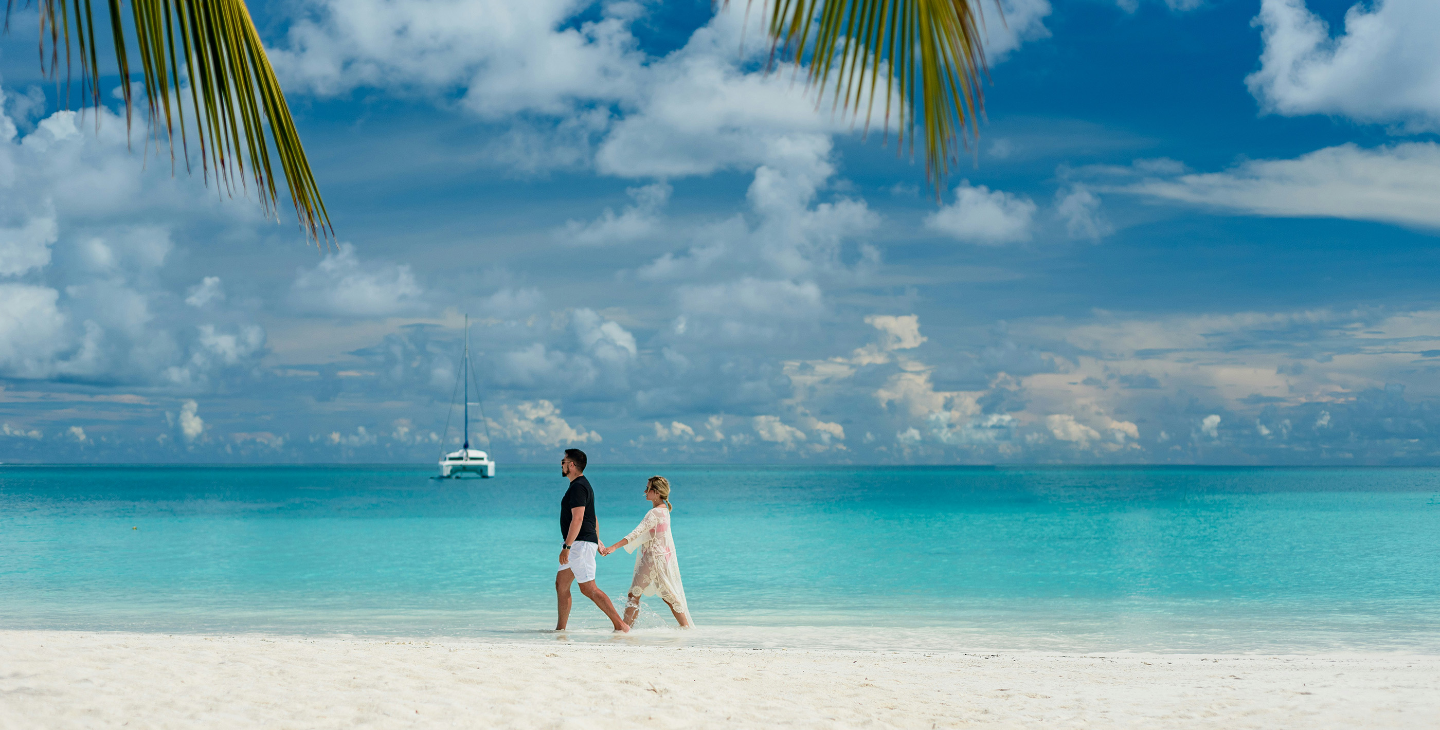 Couple walking along a pristine beach, representing expat living