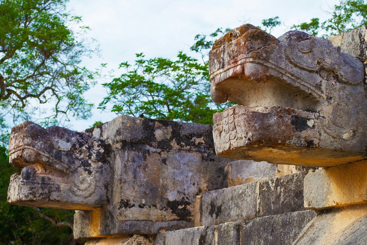 Stone lion head carvings at a Mayan archaeological ruin in Mexico.