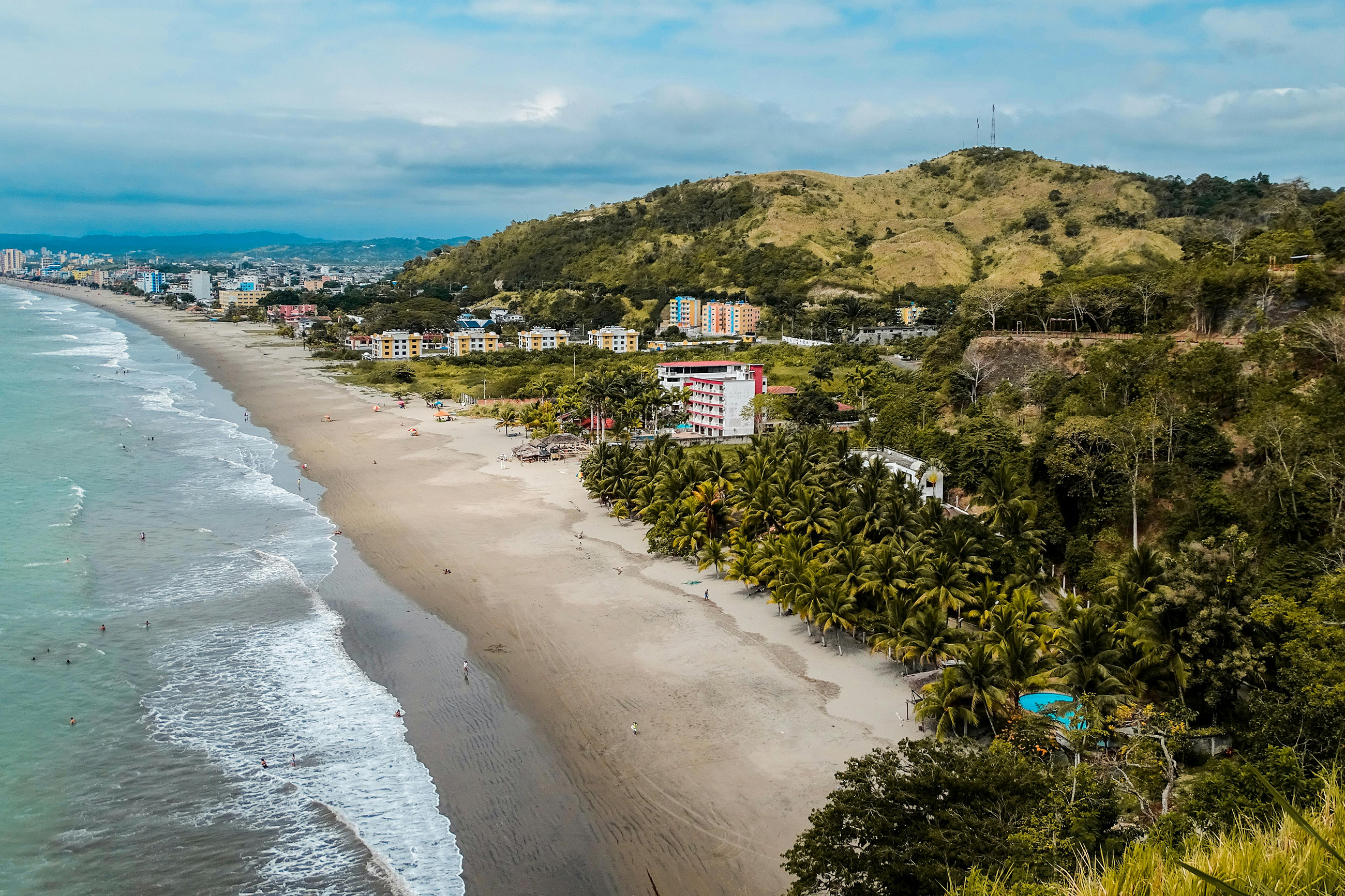 A scenic view of the beach in Salinas, Ecuador, with golden sand, blue waters, and a lively coastal atmosphere.