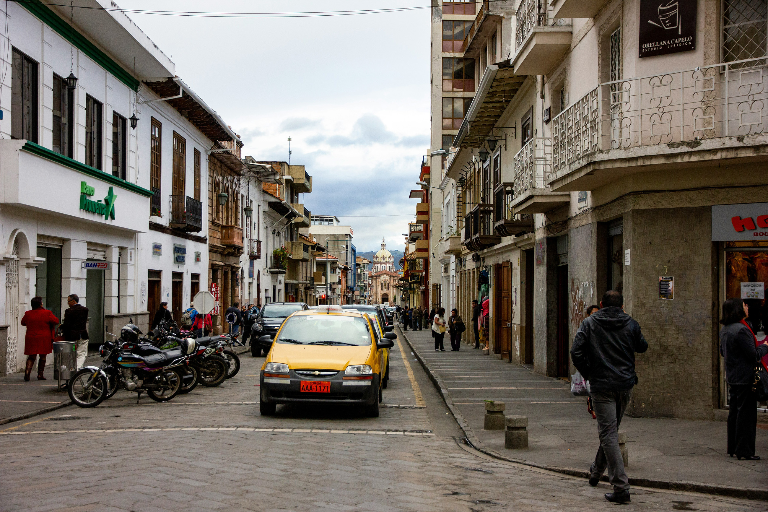 A typical street in a town in Ecuador, lined with colonial-style buildings and local shops.