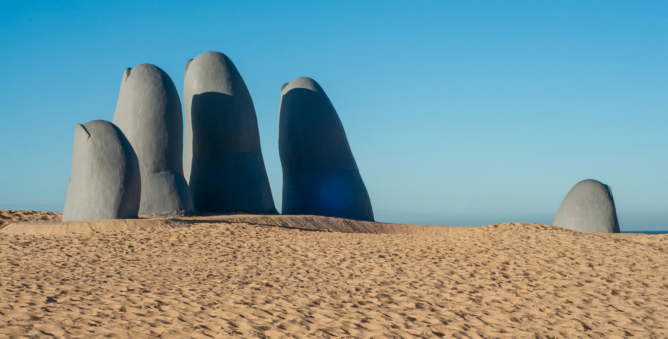 Hand sculpture in sand by the ocean in Punta del Este, Uruguay