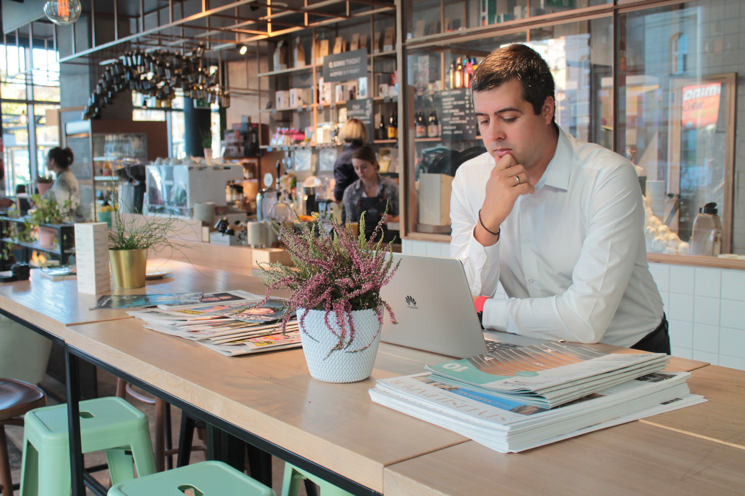 A man working remotely on his laptop at a cafe counter, ideal for remote work.