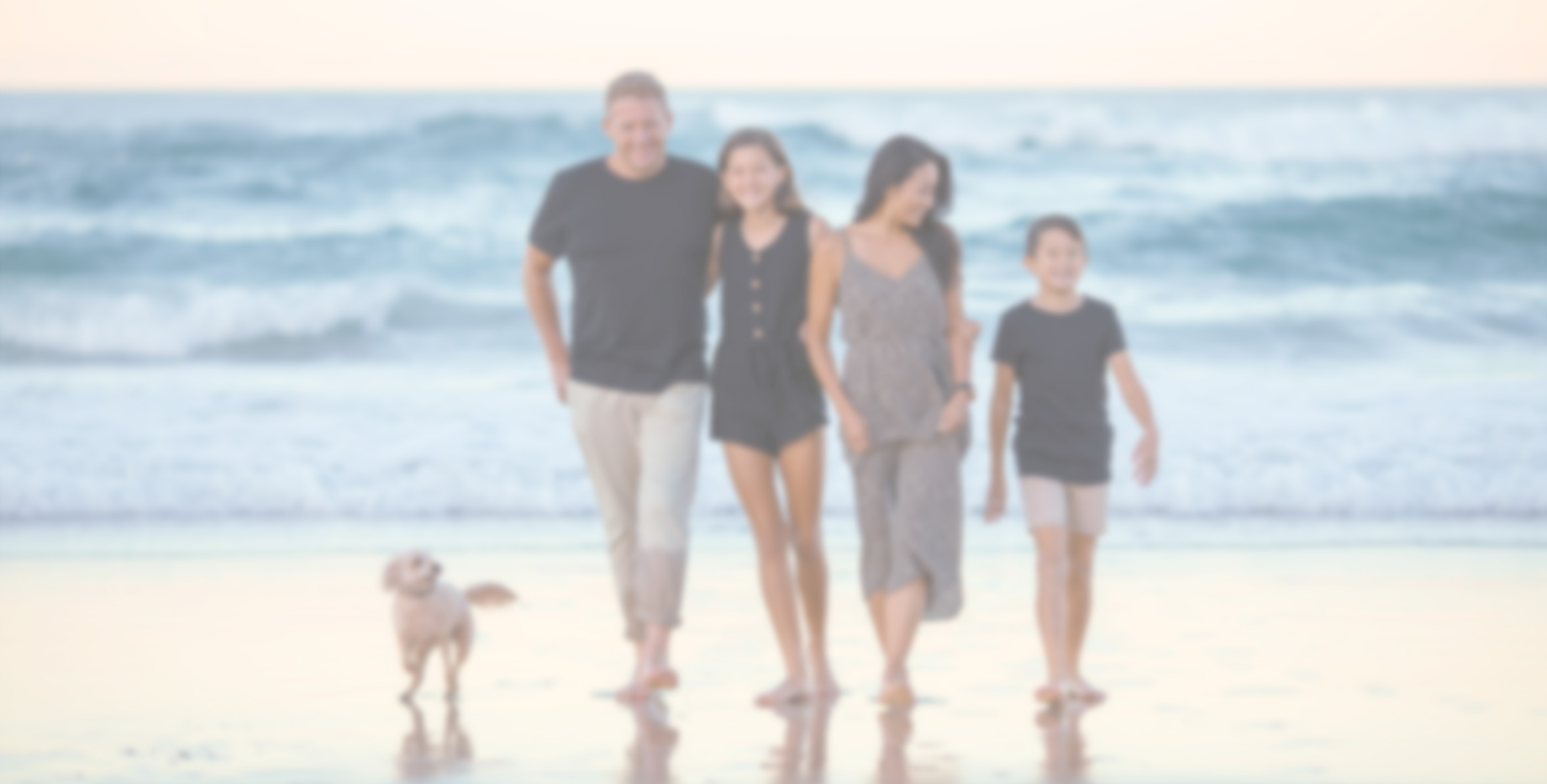 Blurry photo of a family walking away from the beach at sunset, symbolizing freedom and a relaxed lifestyle.