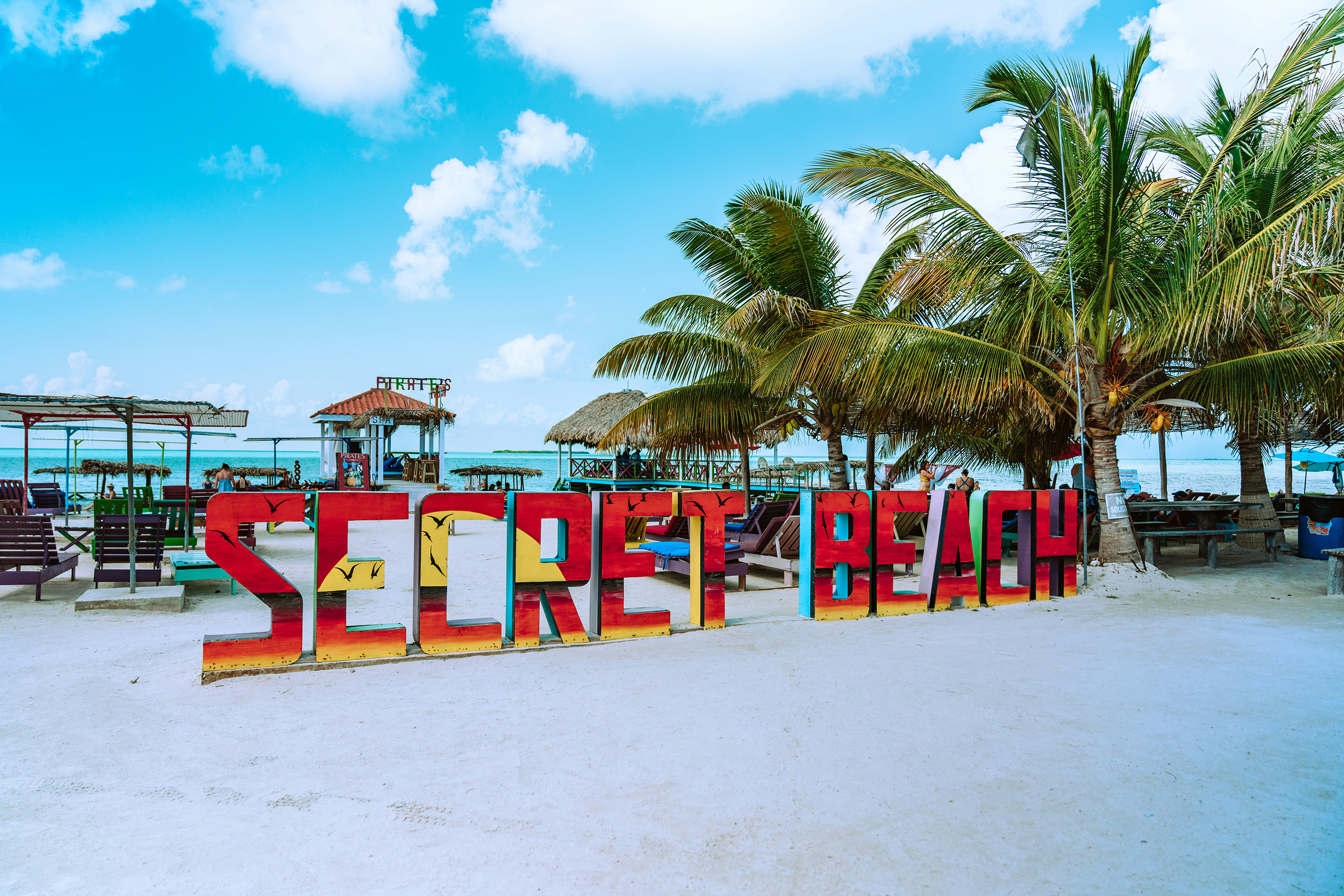 Large colorful Secret Beach sign on Ambergris Caye, a popular spot for expats living in Belize