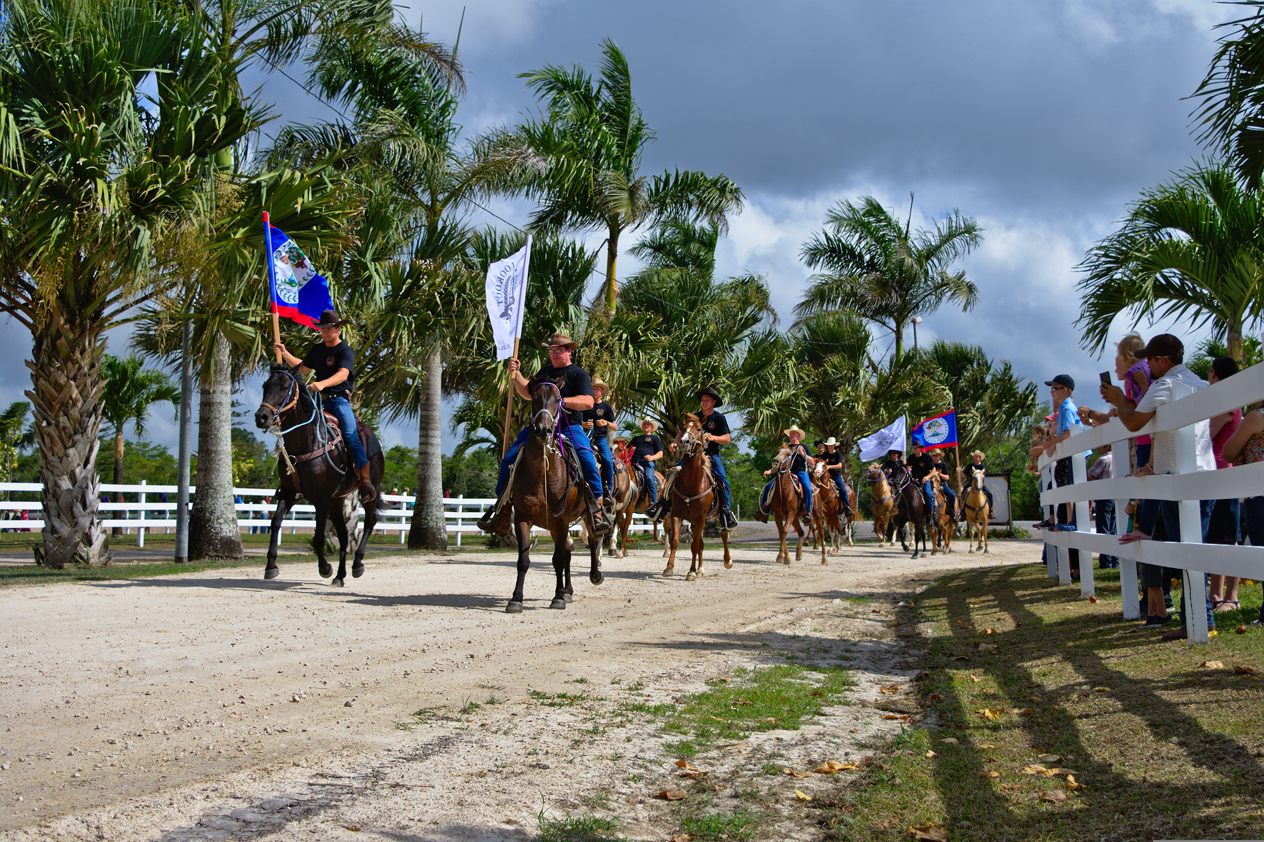 Horseback riders carrying flags in a cultural parade in Belmopan