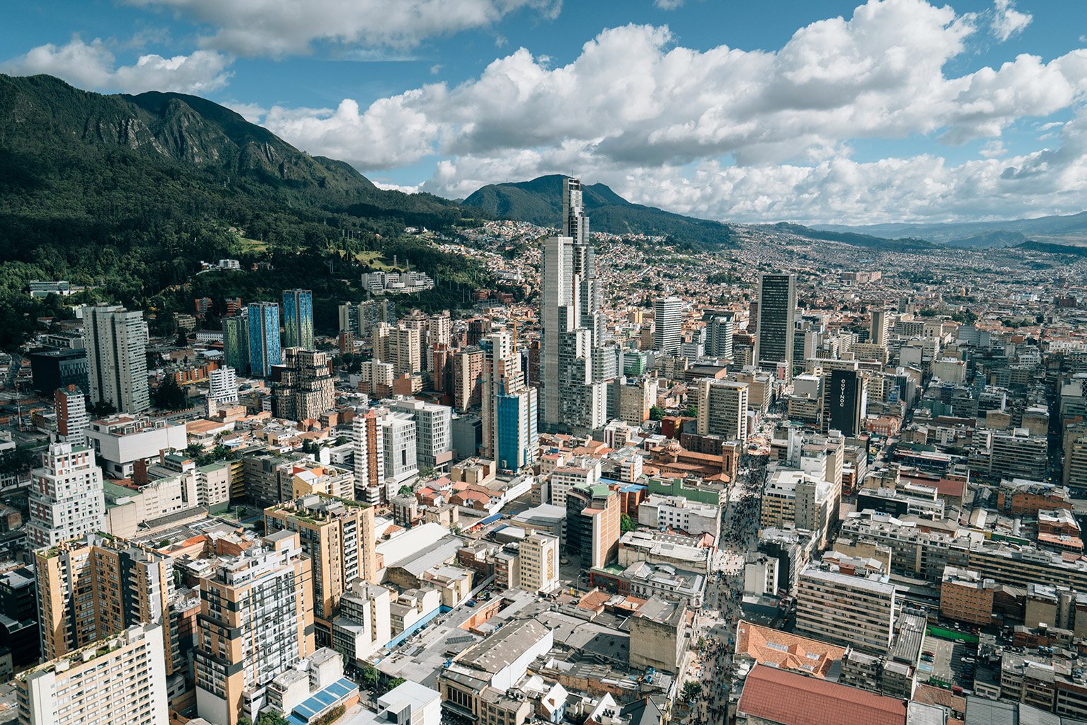 A panoramic view of Bogotá, Colombia, showing the city scape with mountains in the background.