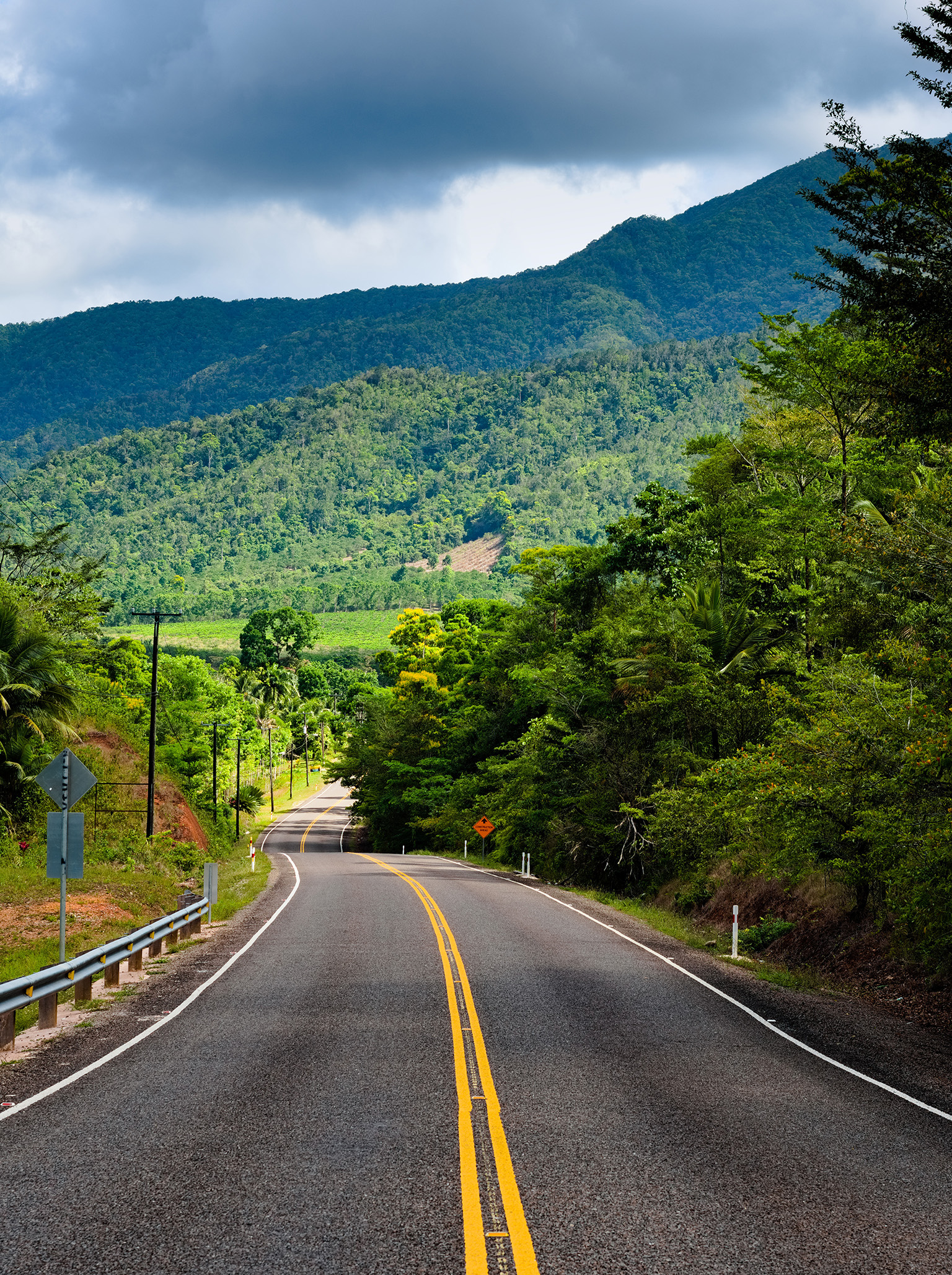 Scenic view of Hummingbird Highway surrounded by jungle and hills