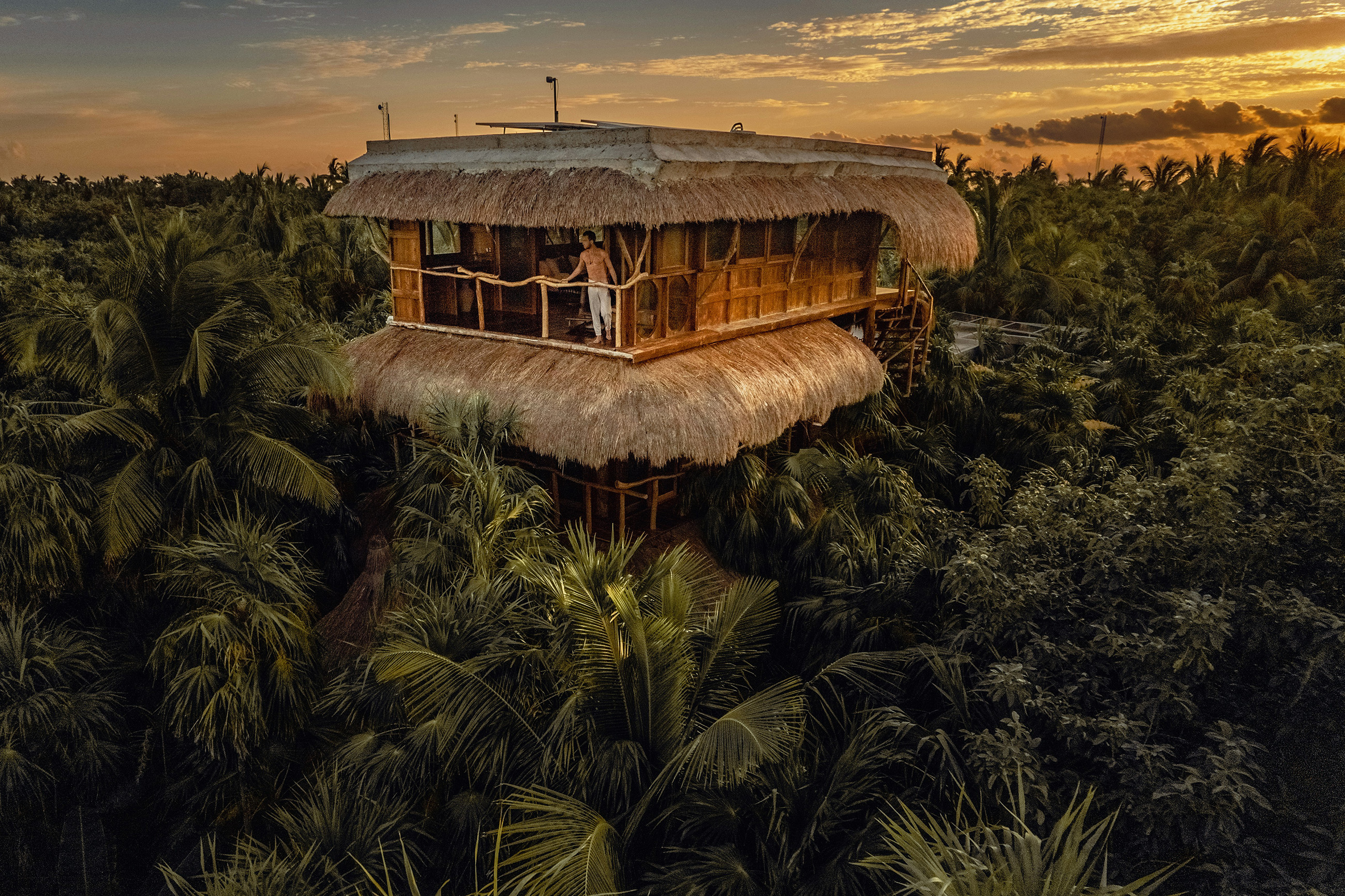 young man enjoying jungle view from a tree house in inland Belize
