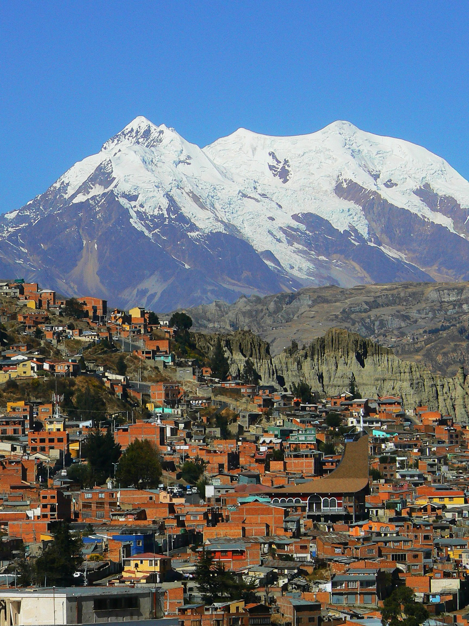 Close-up of houses in La Paz, Bolivia, with snow-capped Andes mountains in the background.