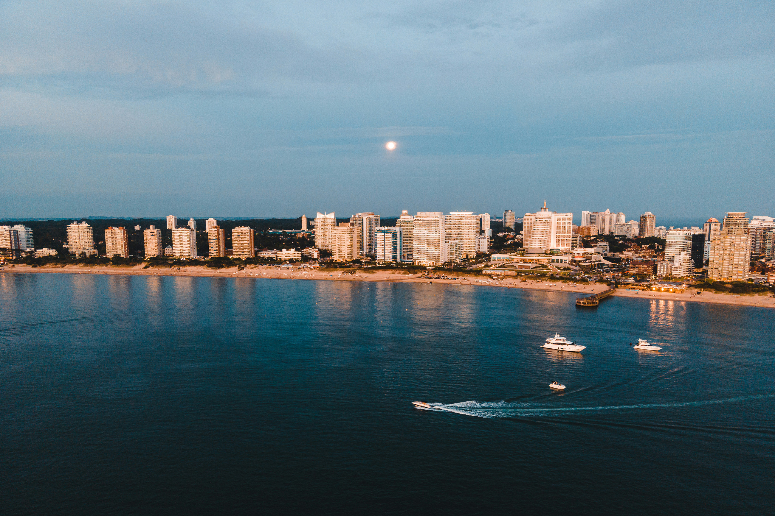 Wide sandy beach in Punta del Este, Uruguay, lined with apartment buildings and clear blue skies.