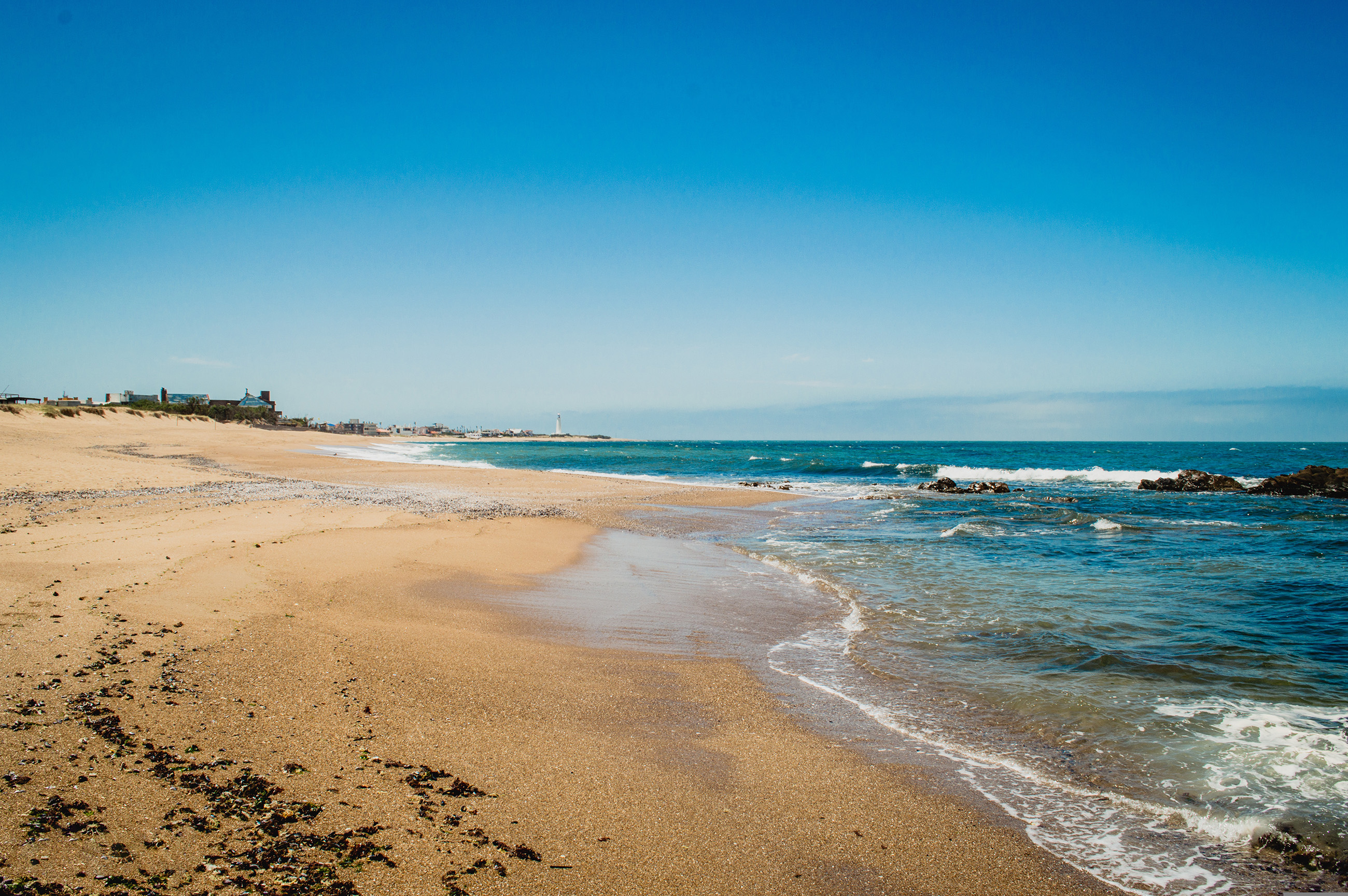 Dramatic coastline of Uruguay with sandy beaches and ocean waves, showcasing the country's natural beauty.