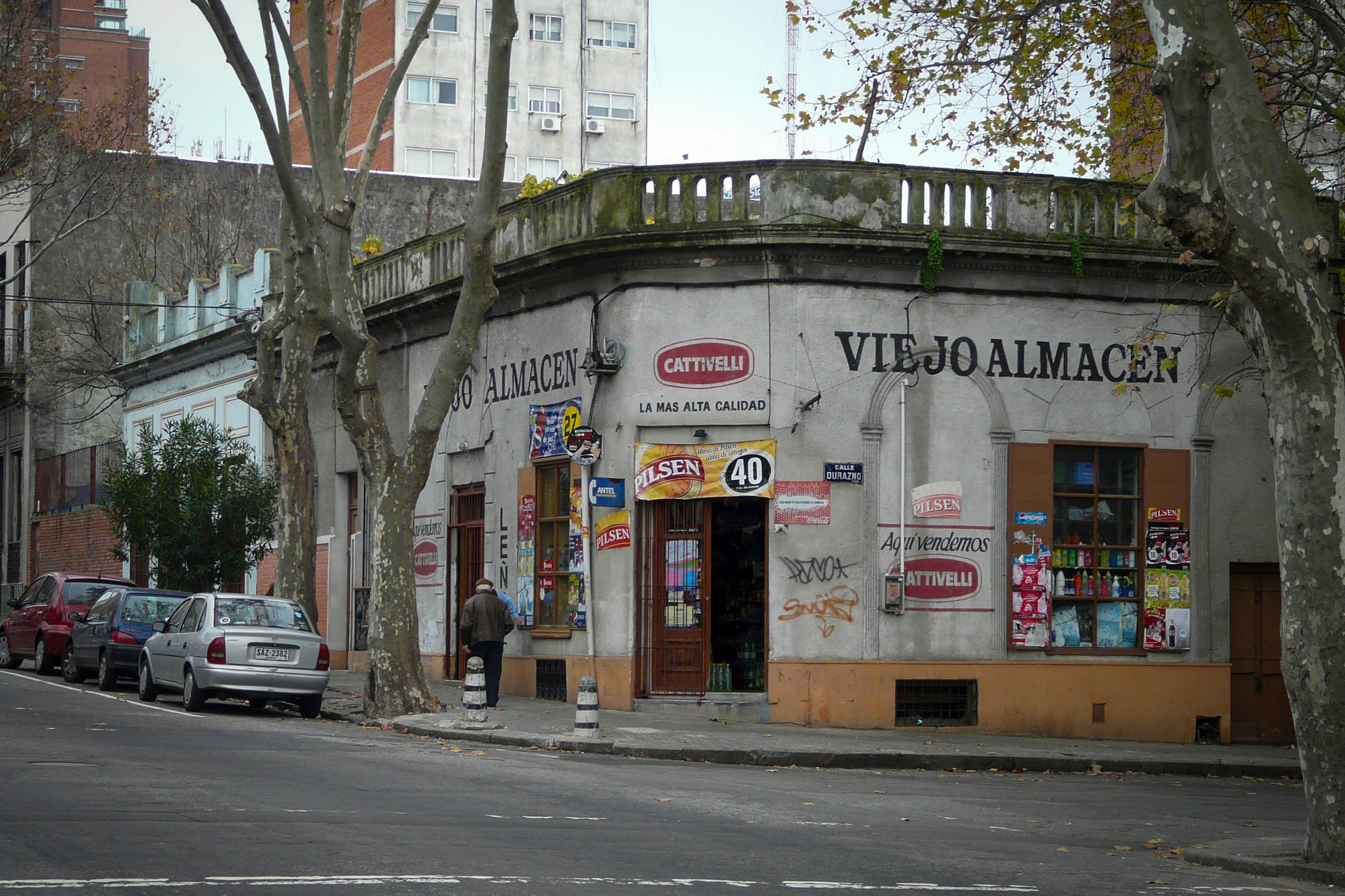 Run-down old store on the corner of a city street in Uruguay, highlighting its weathered architecture.