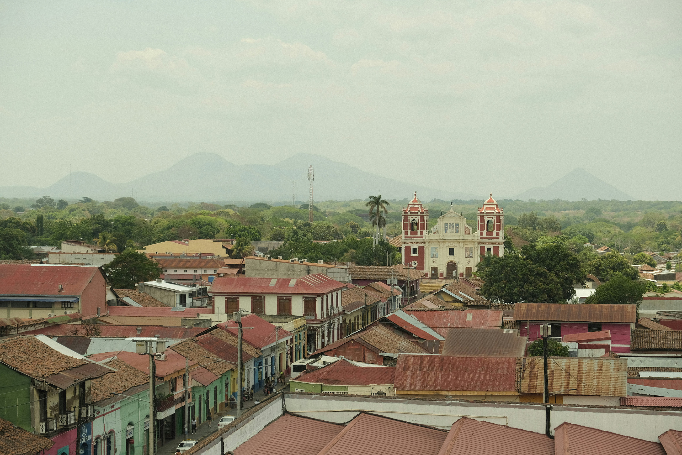 Rooftop view of a colonial church with mountain backdrop in Granada, Nicaragua