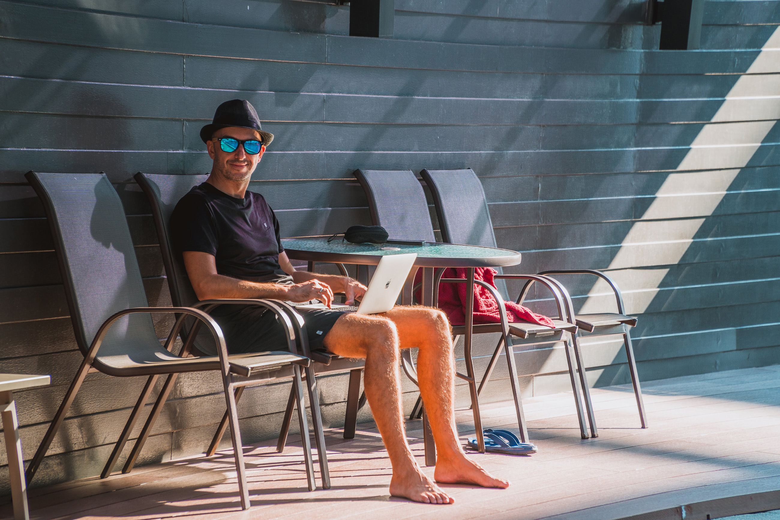 Man working remotely from Belize at a poolside