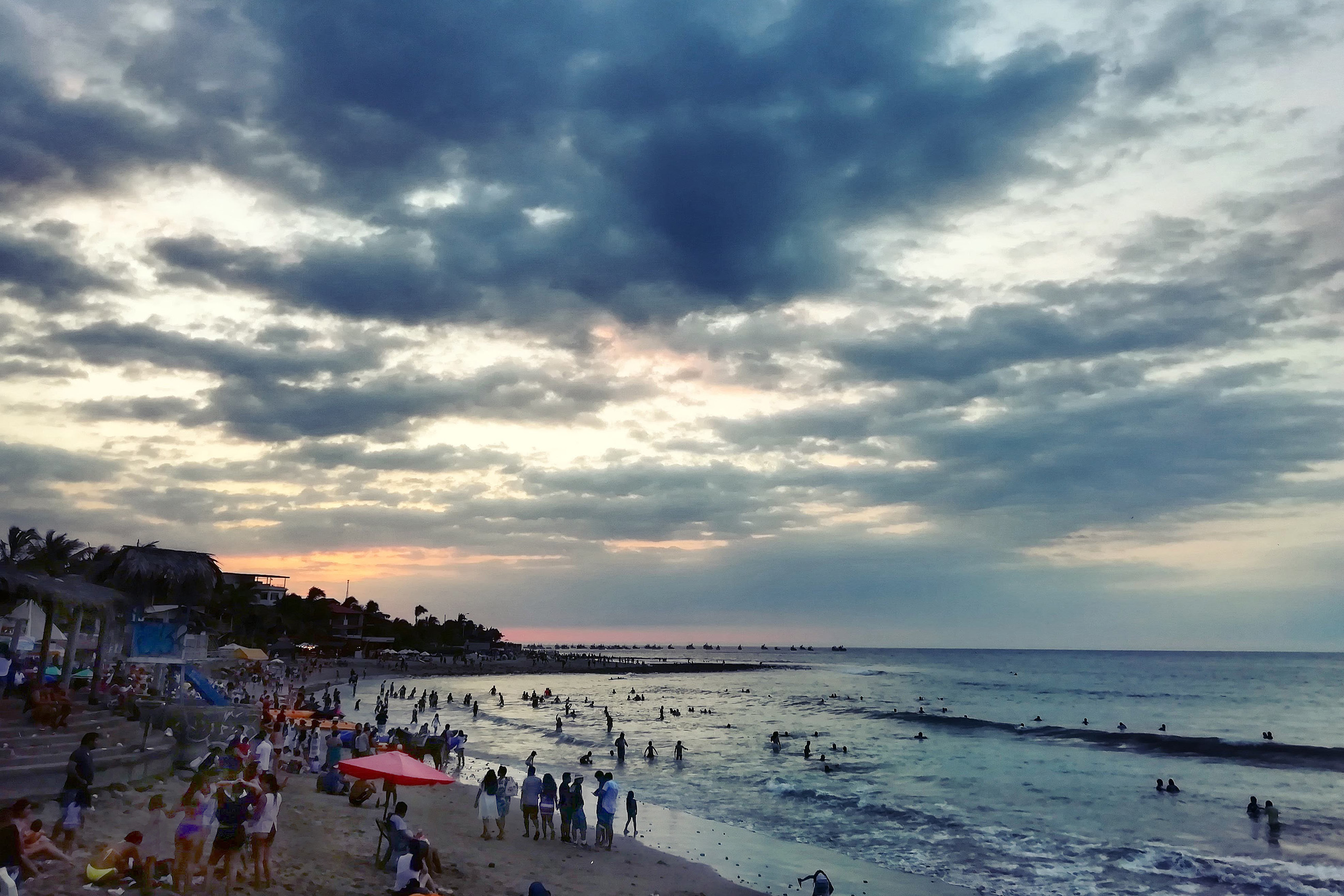 Crowded beach in Máncora Peru at sunset, known for nightlife, surfing, and digital nomads.