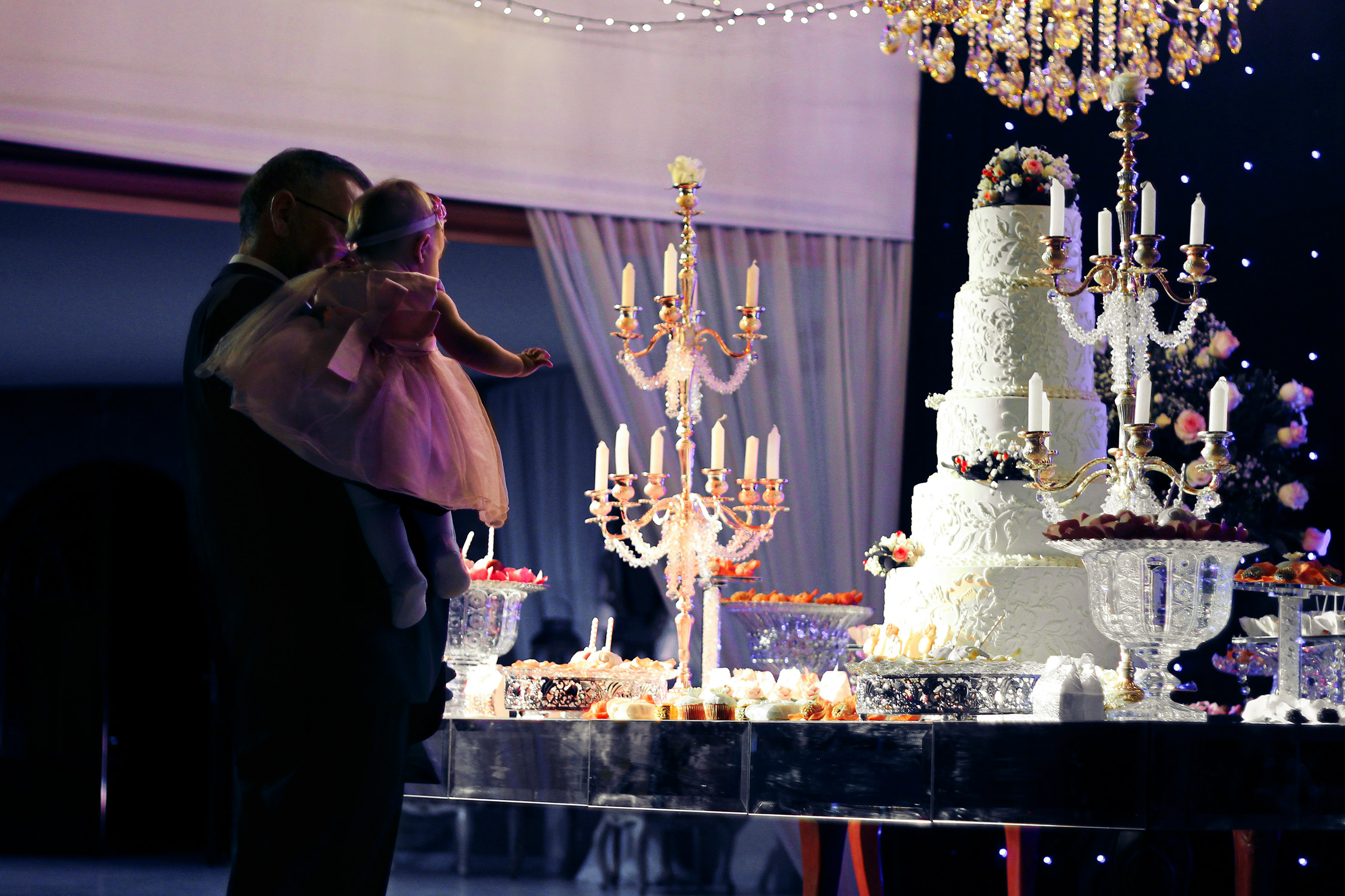 Man holding a young child at a decorated event table.