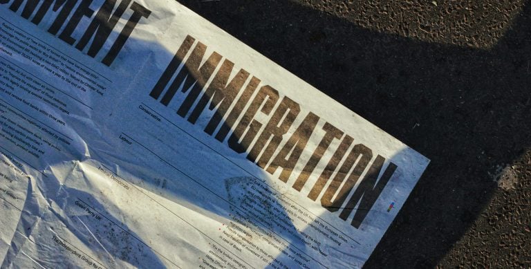 Newspaper headline reading IMMIGRATION in bold letters symbolizing global migration trends and Paraguay residency boom
