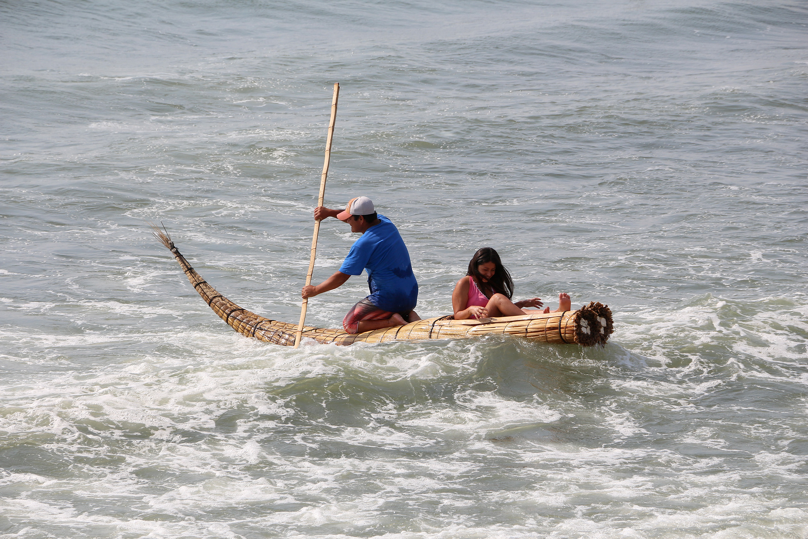 Traditional reed boat ride in Huanchaco Peru, where caballitos de totora are still used by surfers and fishermen.