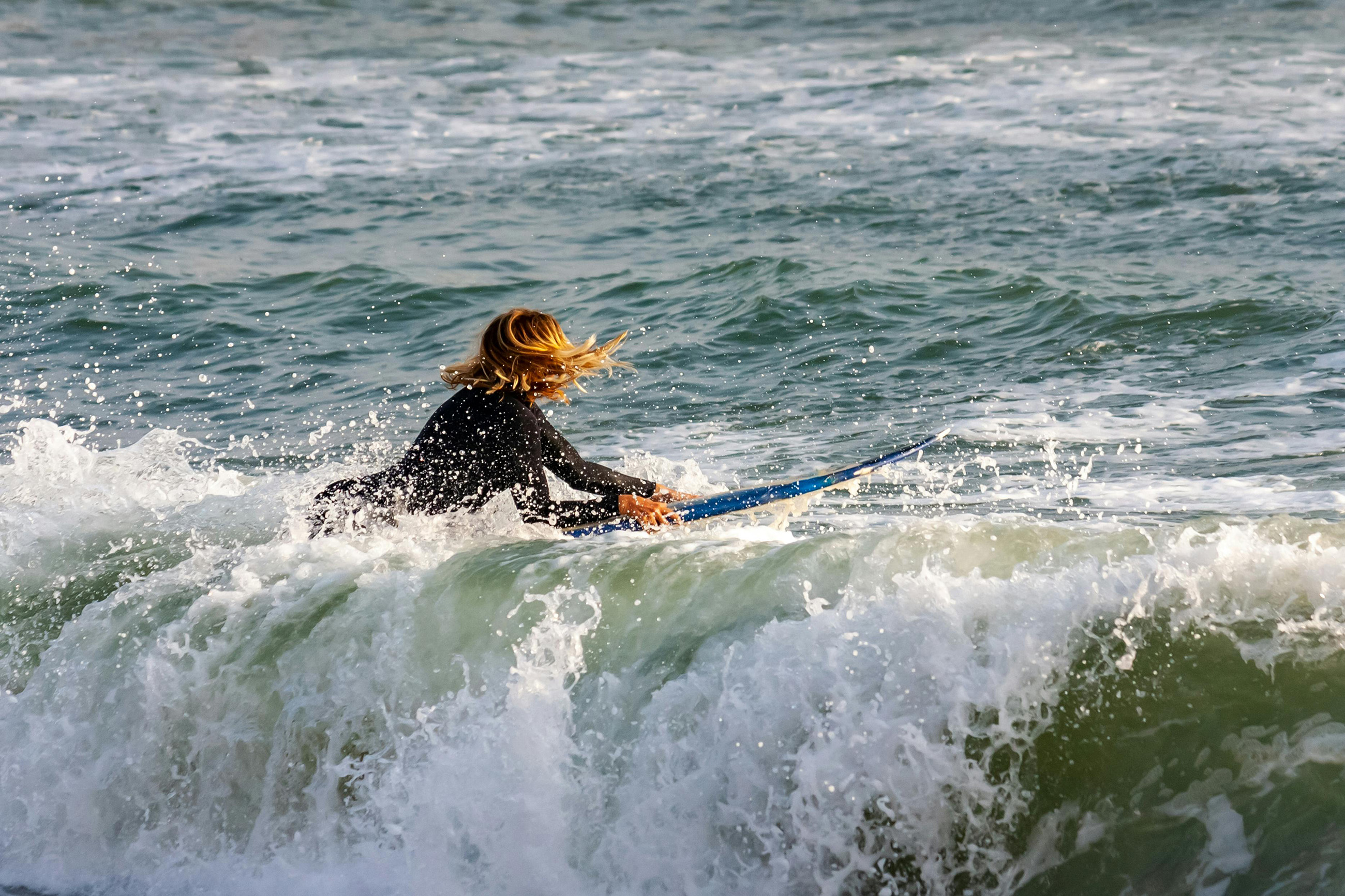 Woman surfing in Máncora Peru, a popular surf destination for expats and nomads.