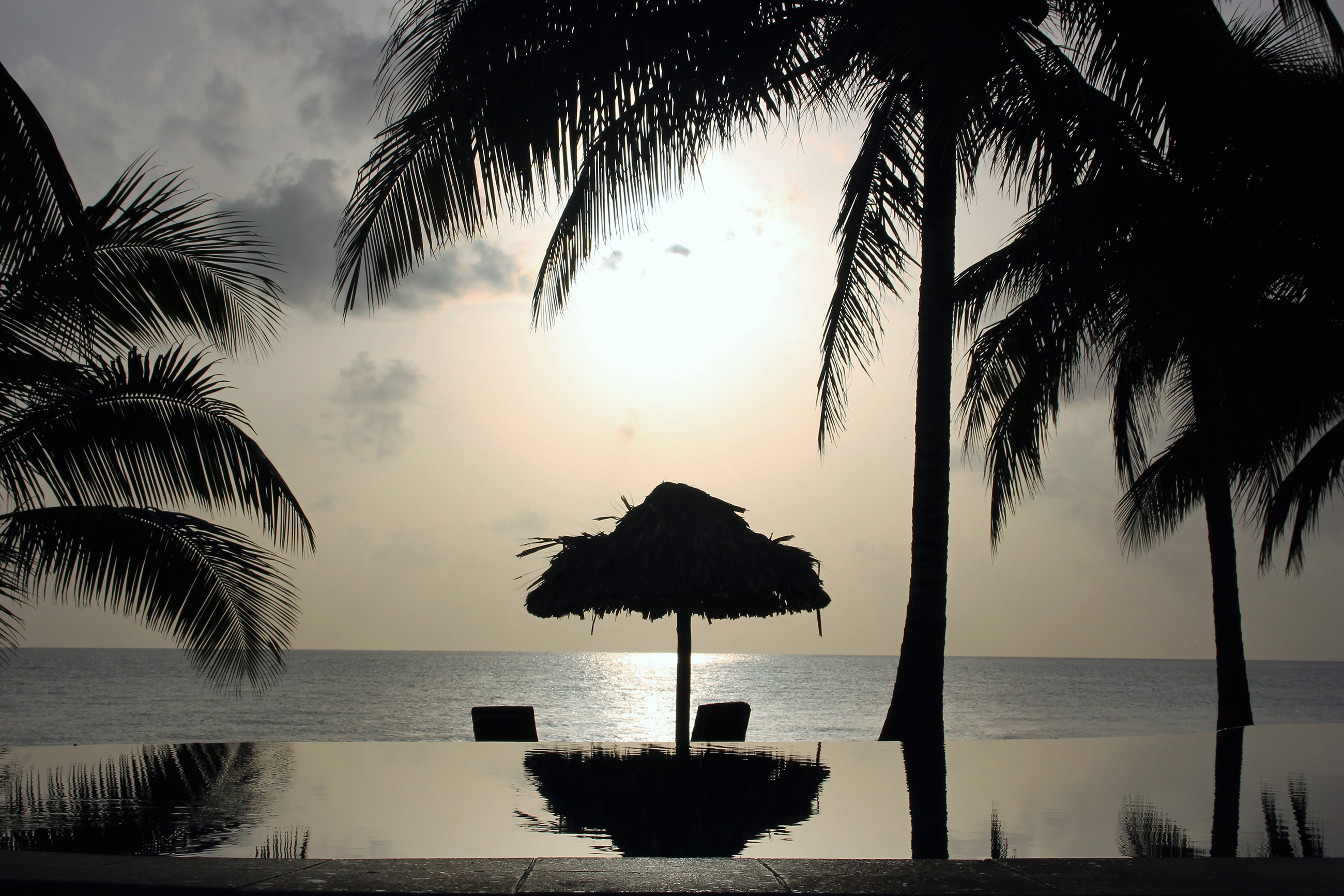 Infinity pool overlooking the ocean in Belize at sunset