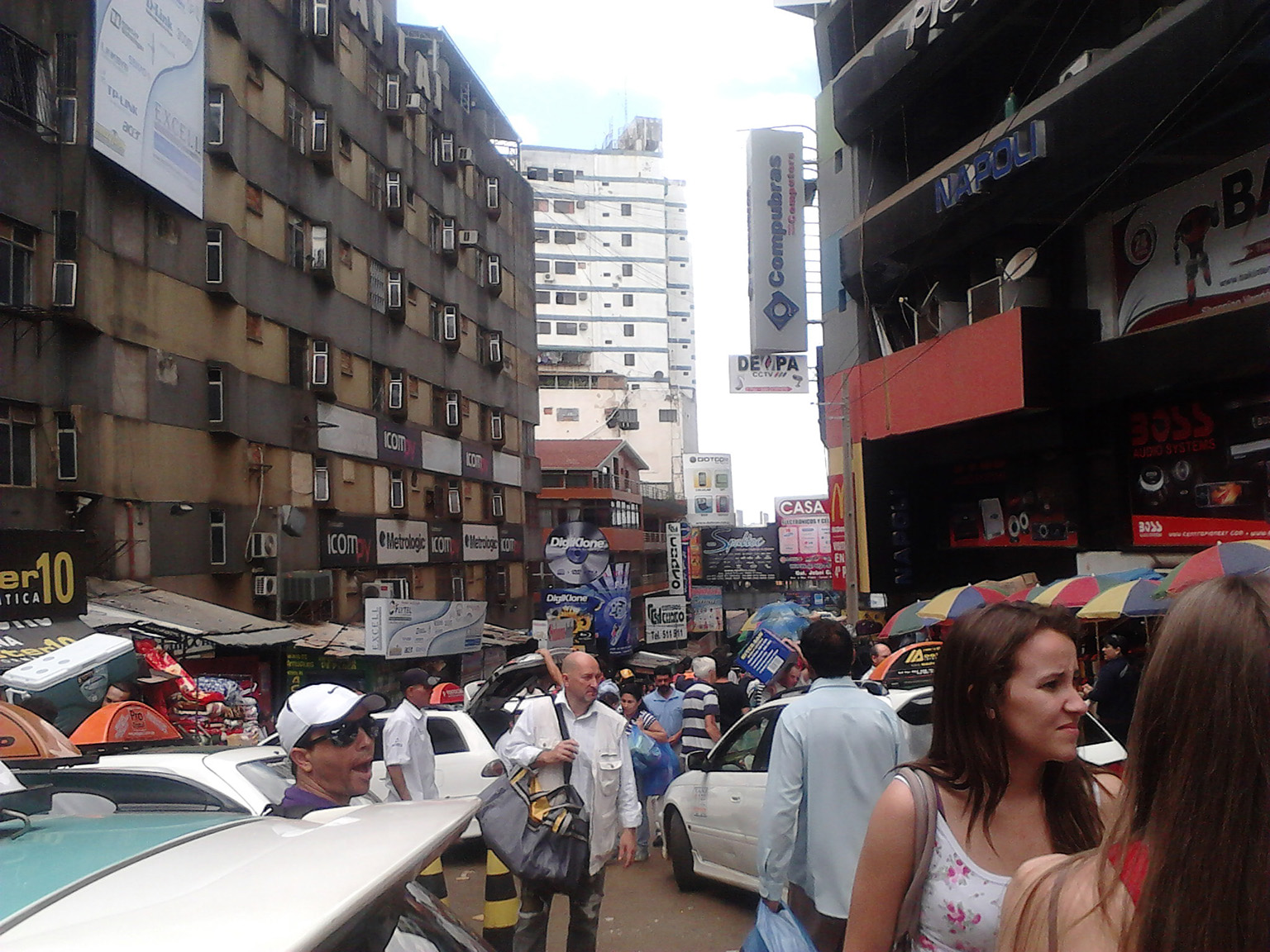 Crowded shopping street in Ciudad del Este filled with vendors, stores, and cross-border shoppers.