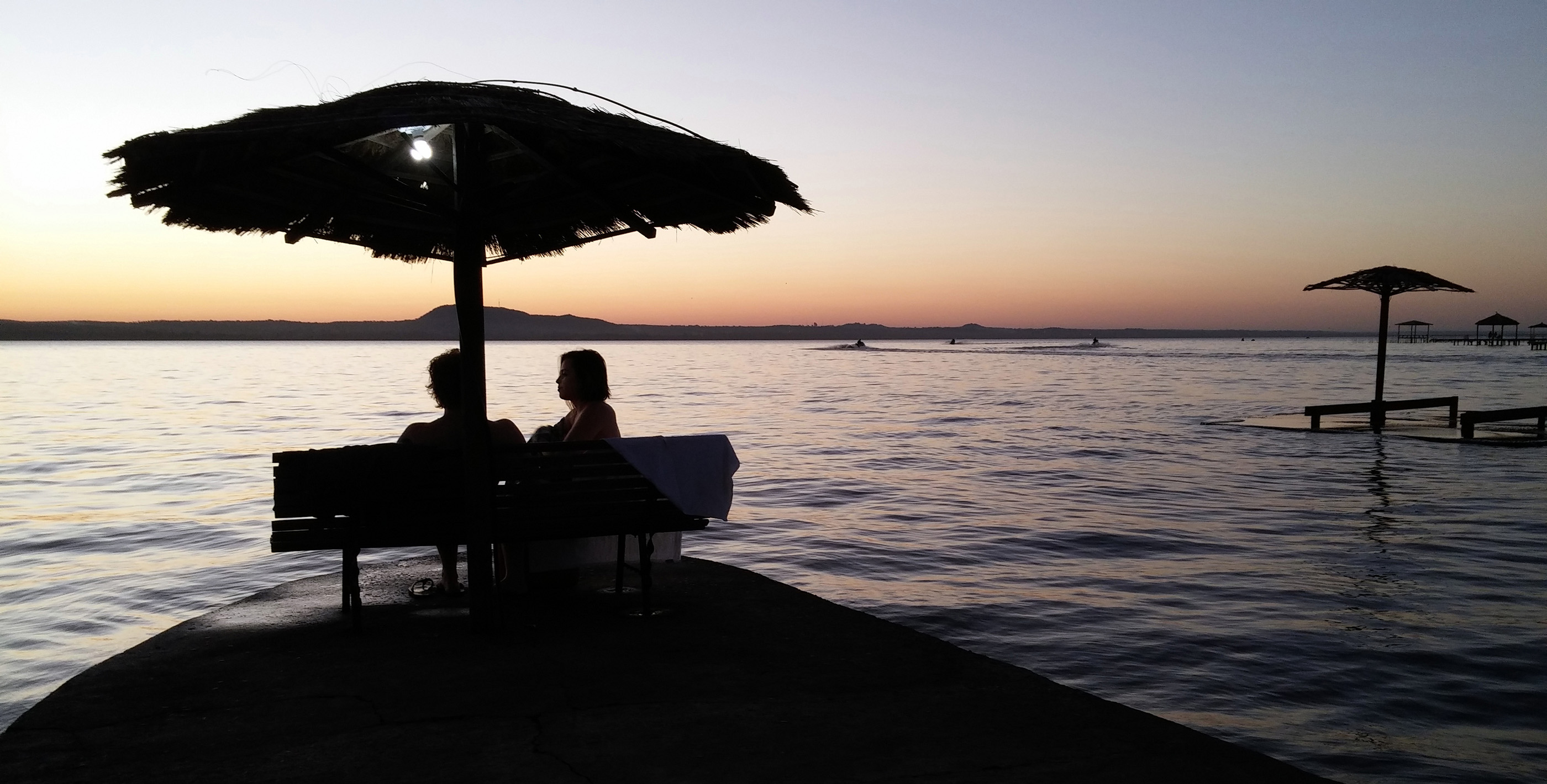 Couple watching the sunset over Lake Ypacaraí while living in San Bernardino Paraguay