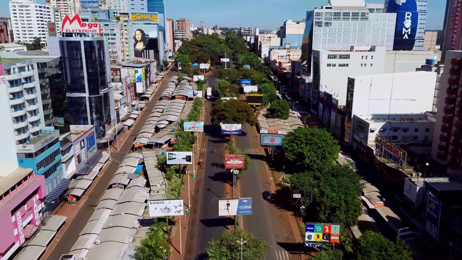 Aerial view of the main street in Ciudad del Este with cars, storefronts, and heavy pedestrian activity.