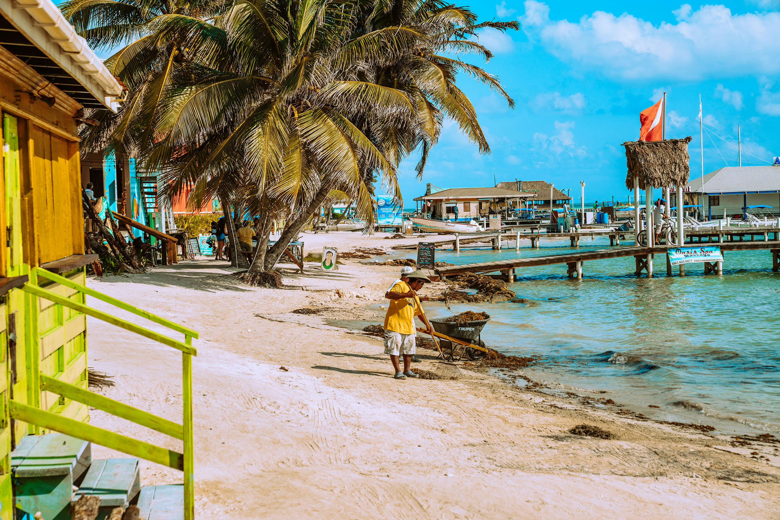Cleaning the shoreline on Ambergris Caye, reflecting community responsibility in Belize daily life
