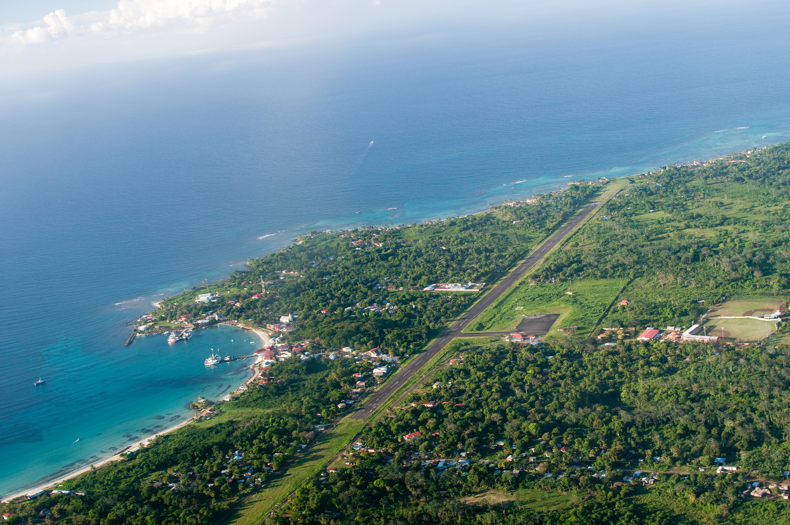 Aerial view of Big Corn Island, Caribbean ocean, lush forest, and landing strip for remote work access