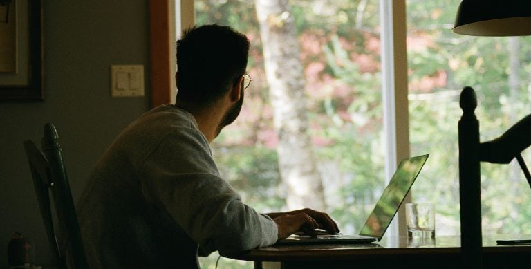 Digital nomad working remotely from home in Paraguay with laptop and natural light