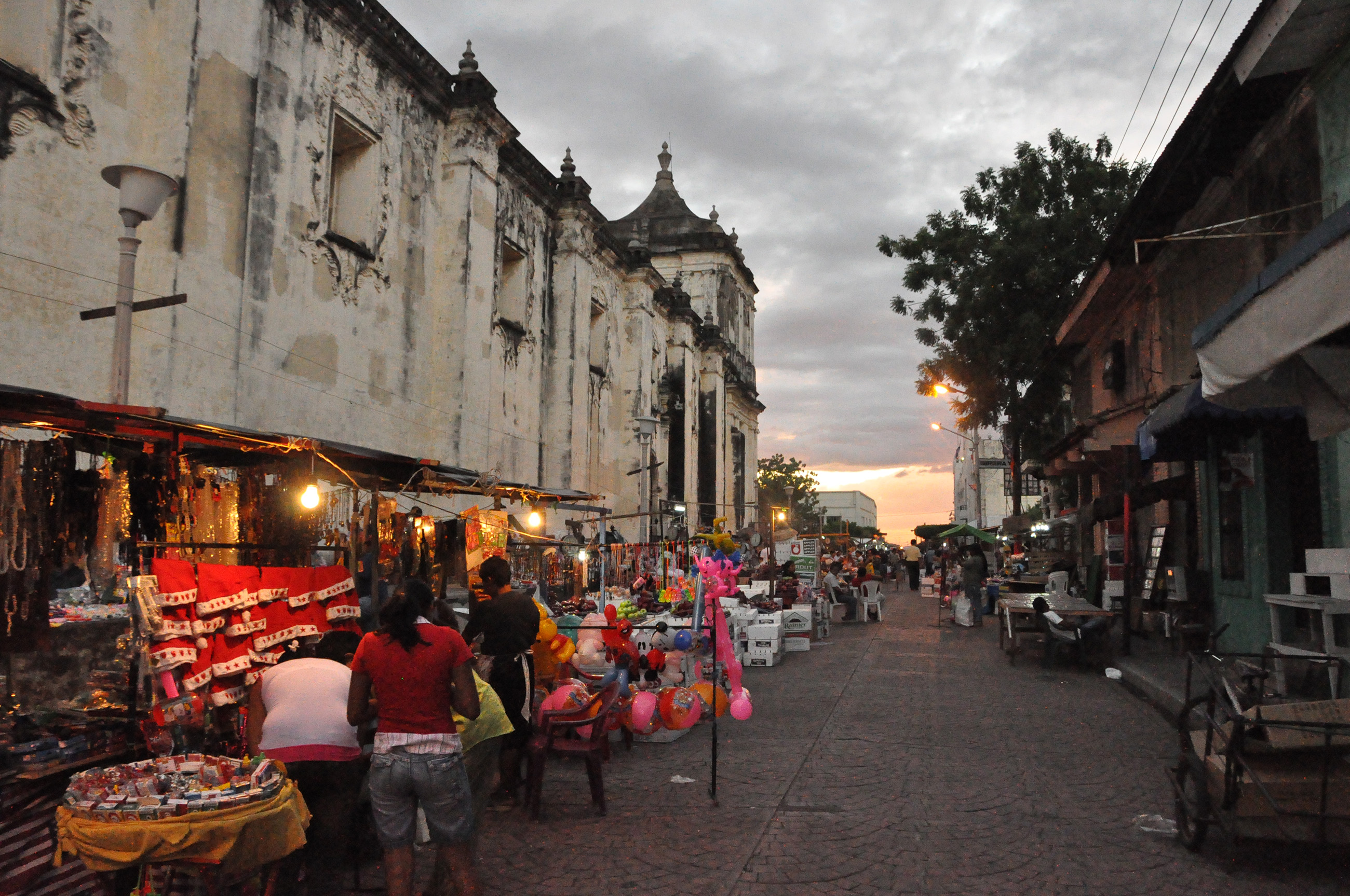Bustling street market in León Nicaragua beside a historic church