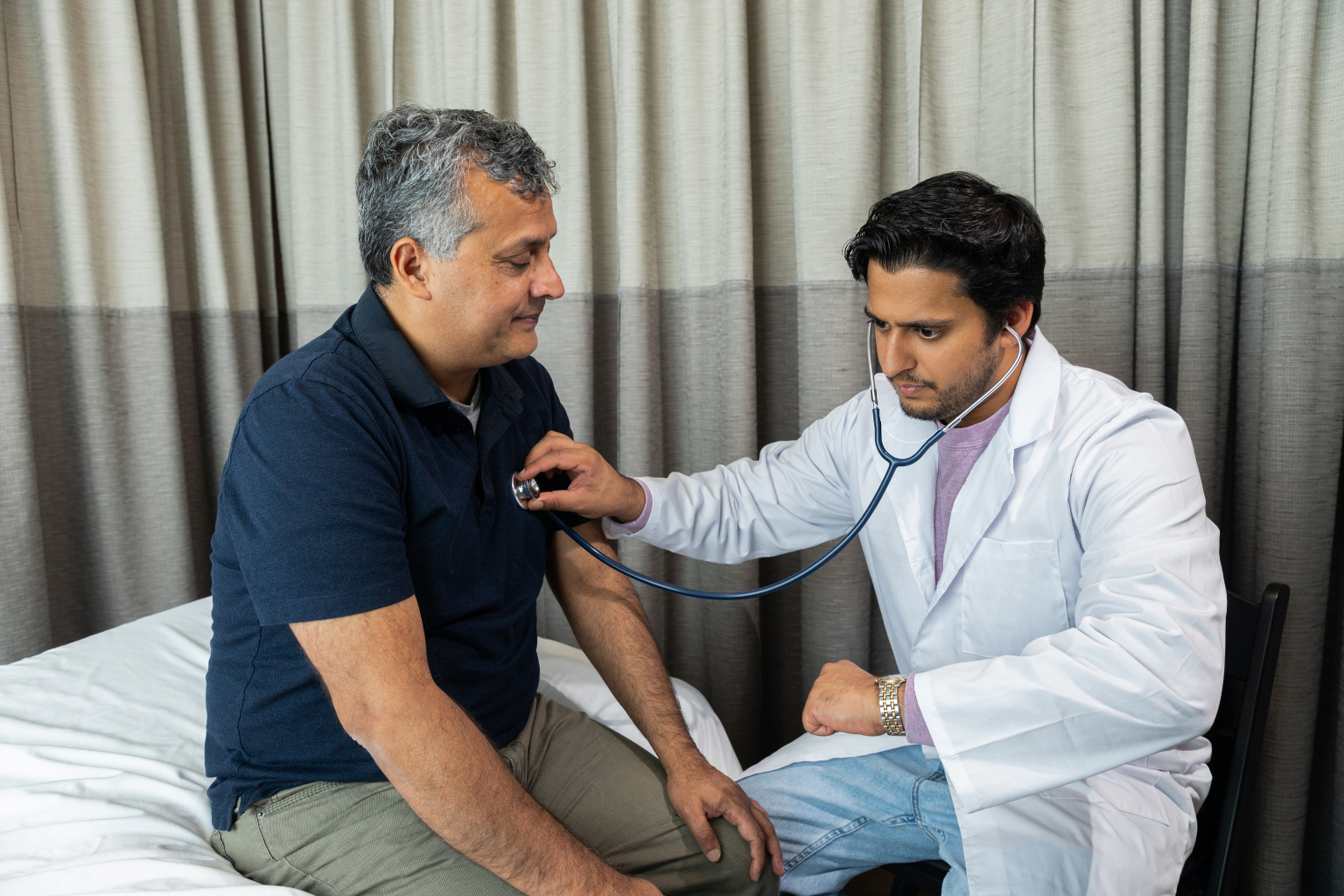Doctor performing heart check on older patient, healthcare in Belize for retirees