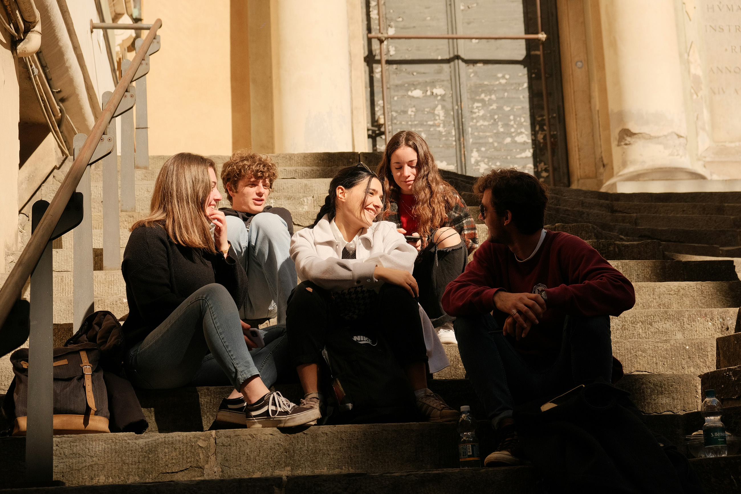 Teenagers socializing on school steps in Paraguay