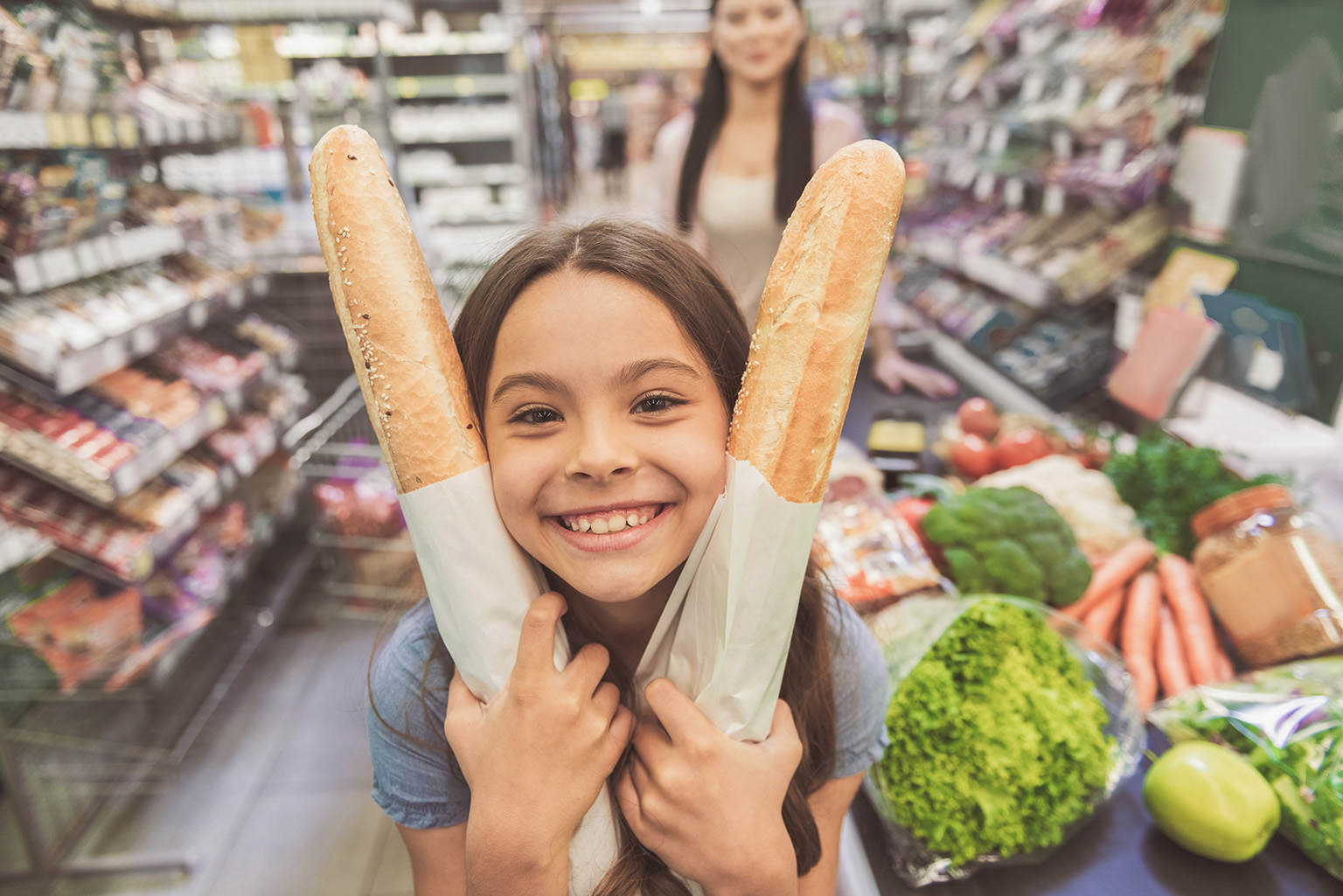 local-shopping-family-living-in-paraguay child holding baguettes smiling with mother local shopping living in Paraguay