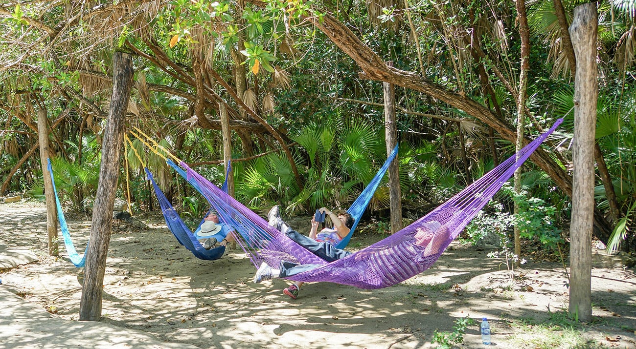 Living in Belize with people relaxing in hammocks on a tropical beach