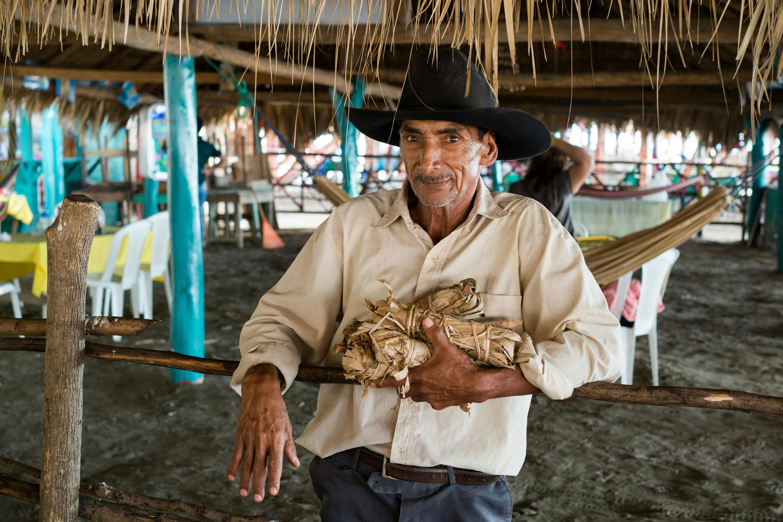 nicaragua-rural-life-local-culture-portrait Elderly man in cowboy hat leaning on wooden fence representing rural life in Nicaragua