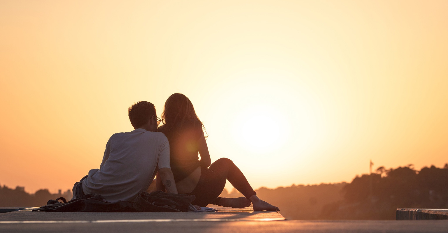 Couple on top of a Belize bus watching sunset - thinking long-term to avoid mistakes moving to Belize