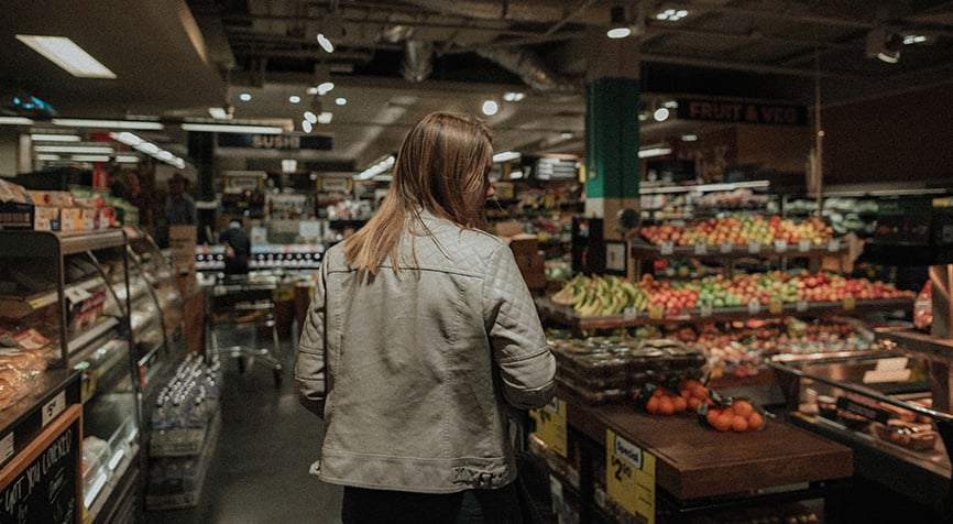 Woman walking through a grocery store aisle, illustrating the cost of living in Paraguay