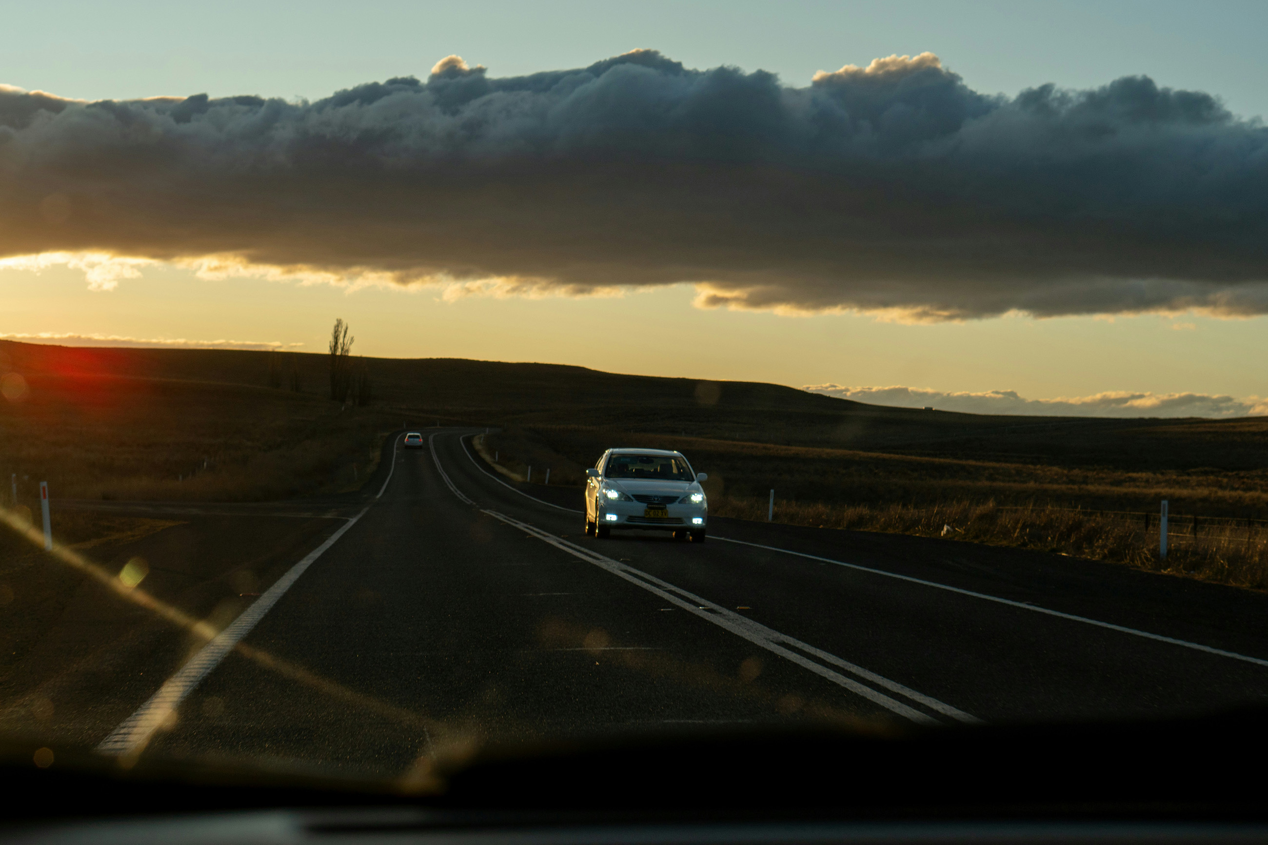 Car driving toward the camera with headlights on, illustrating the question: is driving in Paraguay safe? 