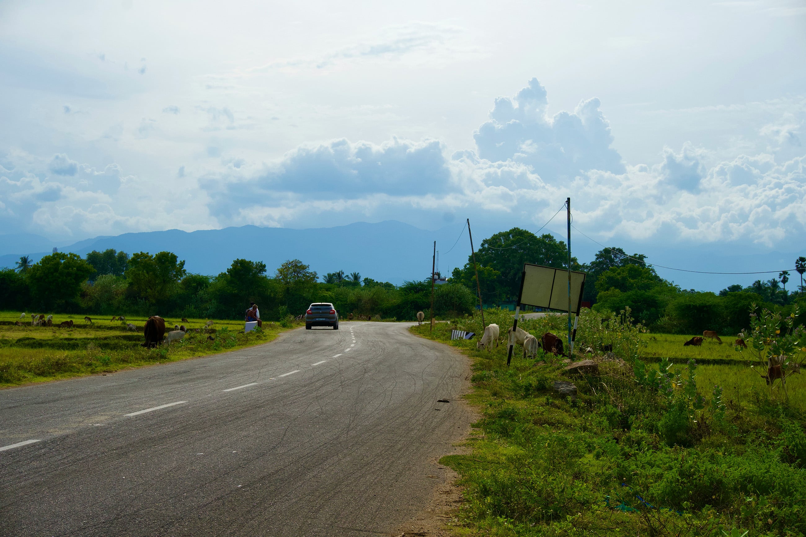Secondary road in rural Paraguay with a car in the background, showing typical road conditions 