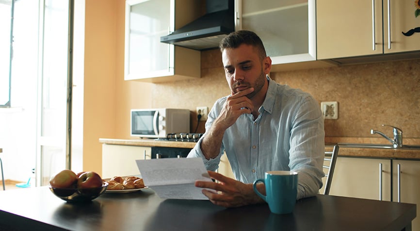 Man reviewing his tax return at the kitchen table, covering taxes for expats living in Paraguay