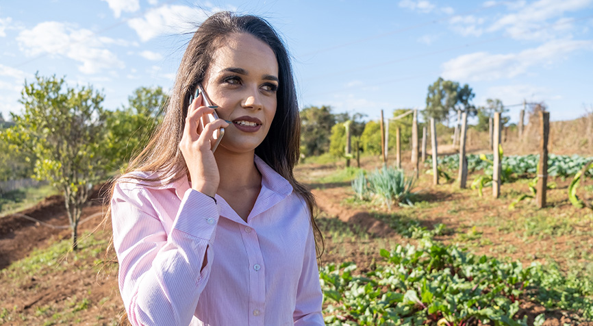 Young woman using a smartphone on a farm illustrating internet access and connectivity in Nicaragua